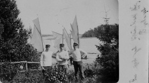 Svågrarna med en kamrat framför segelbåten